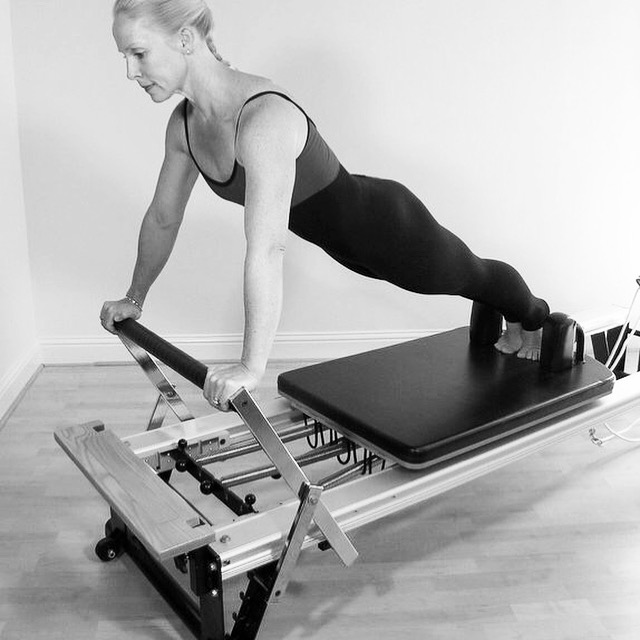 Pilates Instructor on Reformer in Plank