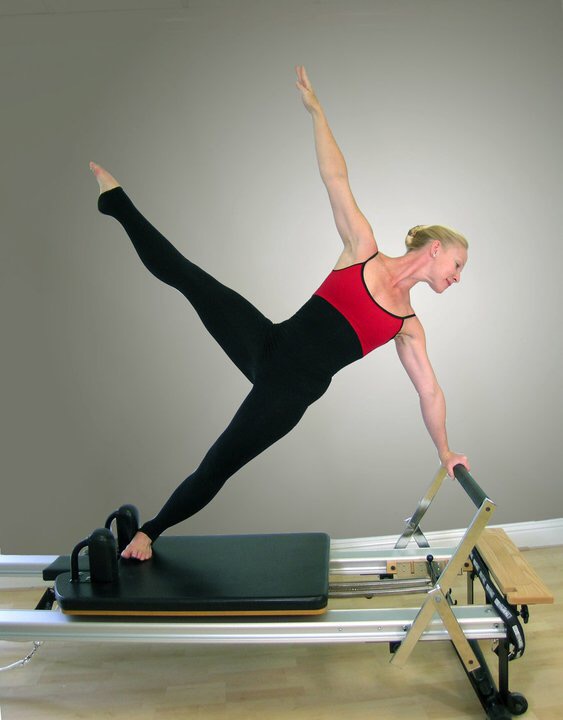 Pilates Instructor on Reformer in Warrior 2